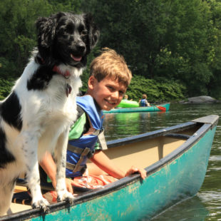 young boy and dog enjoying their canoe ride Indian Head Canoeing Rafting Kayaking Tubing Delaware River
