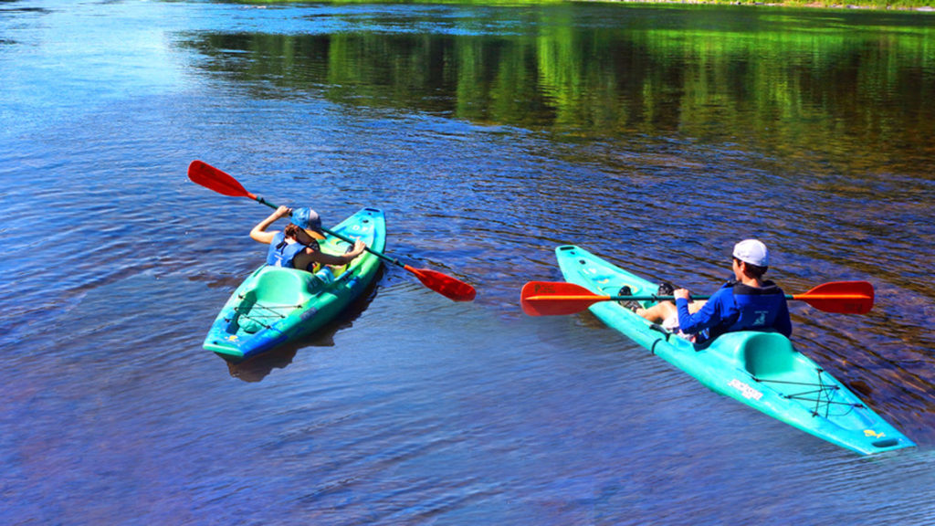 two young men in their own kayaks in Dingmans Ferry Indian Head Canoeing Rafting Kayaking Tubing Delaware River